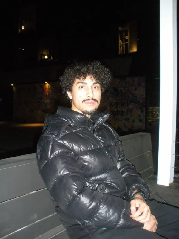 Seated portrait in a black puffer jacket