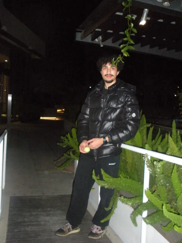 Standing beside plants and a white railing