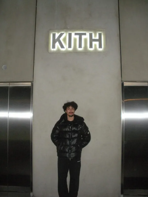 Full-length portrait beneath an illuminated sign