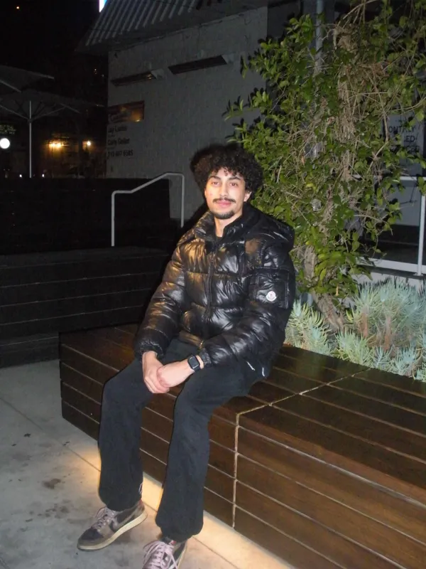 Seated beside leafy plants