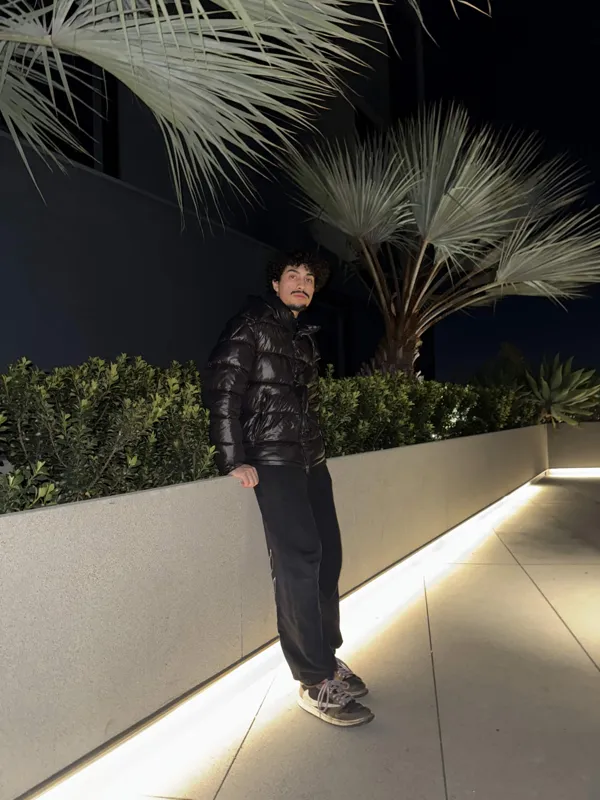 Leaning beside a palm tree at night