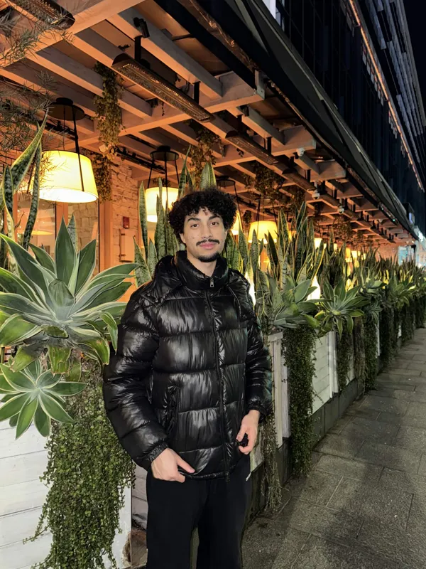 Ethan Exner beside plants and warm hanging lights